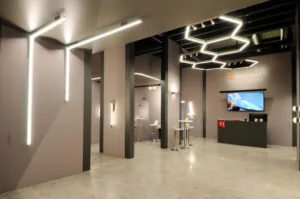 Allestimento fieristico Team Italia fiera euroluce moderno con illuminazione LED geometrica, colonne divisorie e desk informativo, ideale per fiere ed eventi aziendali.