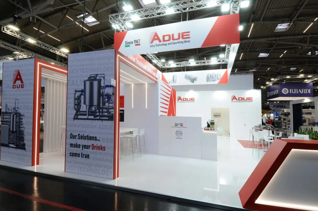 Allestimento stand A DUE spa - Drinktec 2025 di Monaco Stand ADUE a una fiera industriale, con slogan "Juicy Technology and Sparkling Ideas" e soluzioni per il settore beverage.