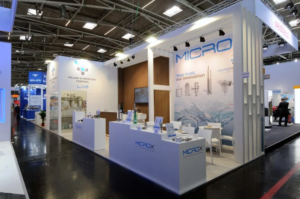 Micropneumatic - Drinktec 2025 di Monaco Stand Micropneumatic con design bianco e blu, tecnologie per laboratorio e controllo fluidi, esposizione prodotti e area incontri.