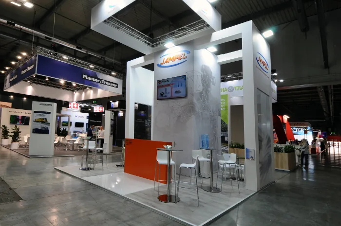 Allestimento stand JAMPEL a Expo Ferroviaria 2025: design moderno con dettagli arancioni, spazi interattivi e branding per il settore ferroviario.